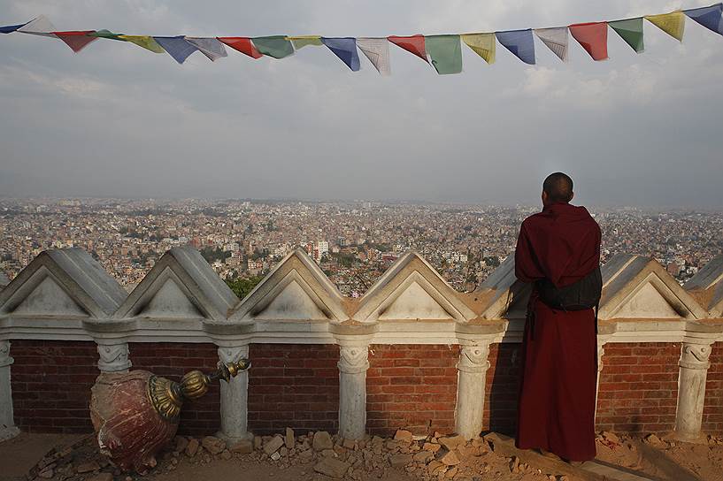 Катманду, Непал. Буддийский монах смотрит на разрушенный землетрясением город со ступы Сваямбунатх, расположенной в центре храмового комплекса, который также пострадал от стихийного бедствия