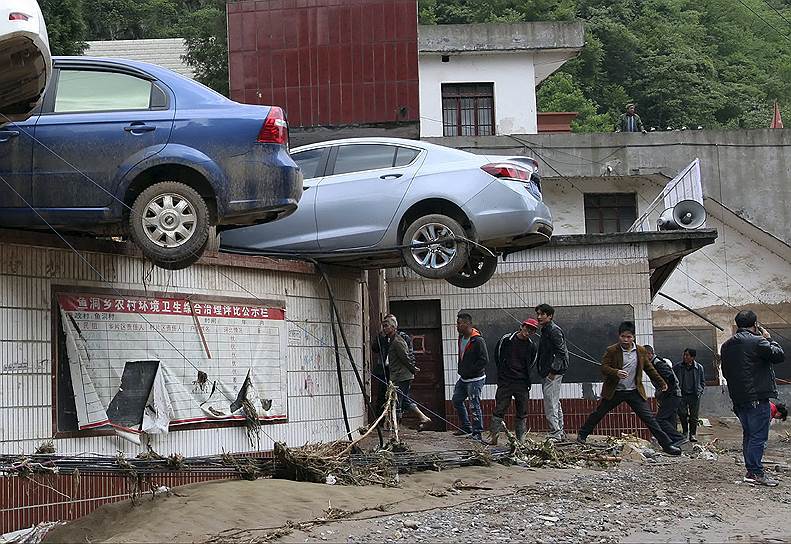 Провинция Юньнань, Китай. Автомобили, оказавшиеся на крыше одного из зданий после паводков