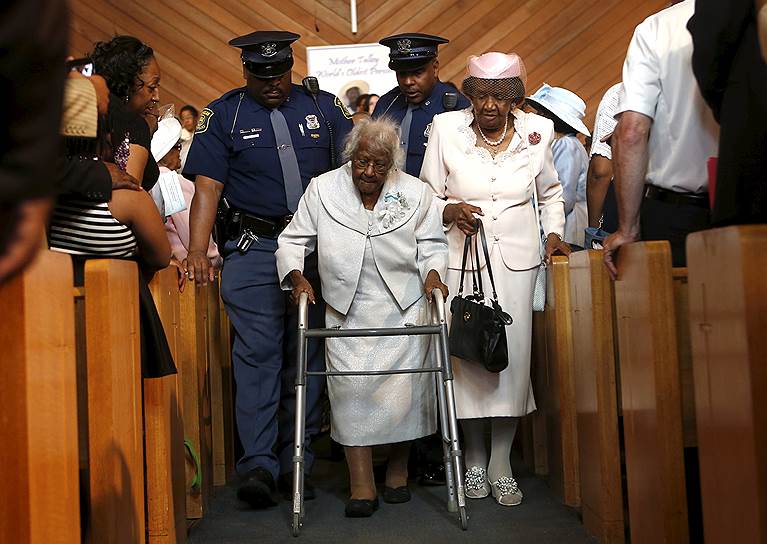 Инкстер, штат Мичиган, США. Джералин Тэлли (в центре), старейшая жительница планеты, выходит из церкви после праздничной службы по случаю ее 116-летия