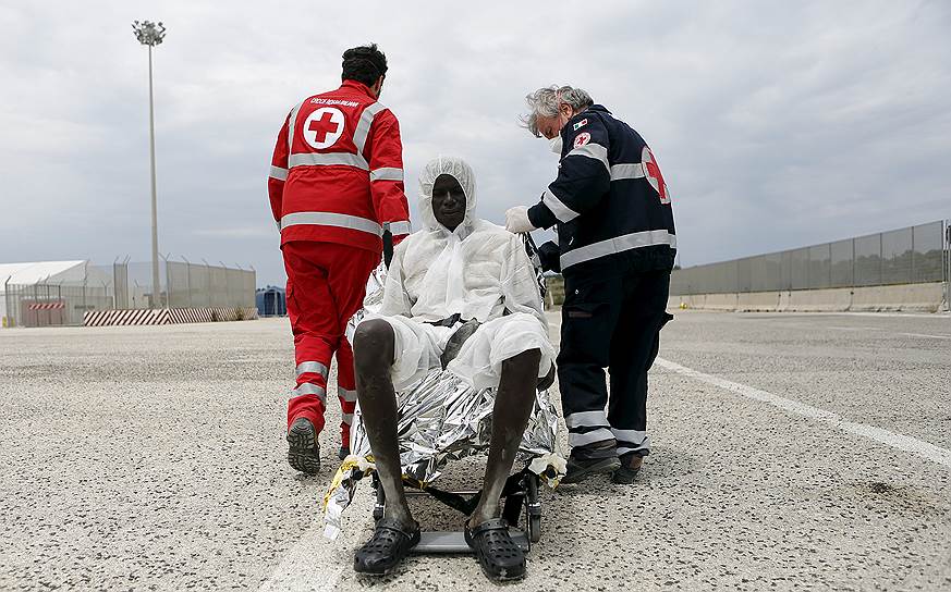 Аугуста, Италия. Работники «Красного креста» помогают мигранту из Африки, пережившему плавание через Средиземное море