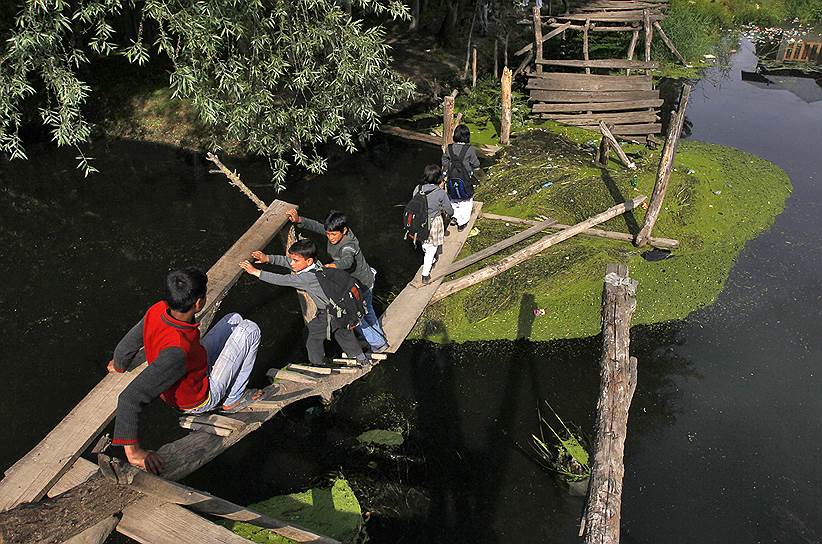 Чтобы попасть из школы домой, дети в Кашмире строят мост вместо снесенного наводнением