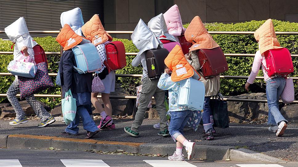 Детей в Токио просят носить специальные головные уборы по дороге в школу и из нее, которые в случае землетрясения должны защитить их 