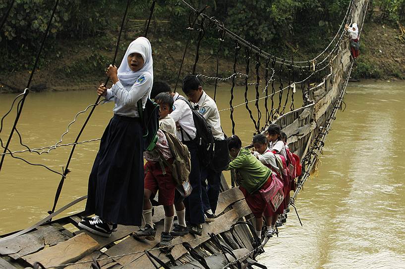 Дети из округа Лебак в индонезийской провинции Бантен каждый день проходят по сломанному подвесному мосту, чтобы добраться до школы. В противном случае, говорят ученики, путь до учебного заведения займет у них на 30 минут больше 