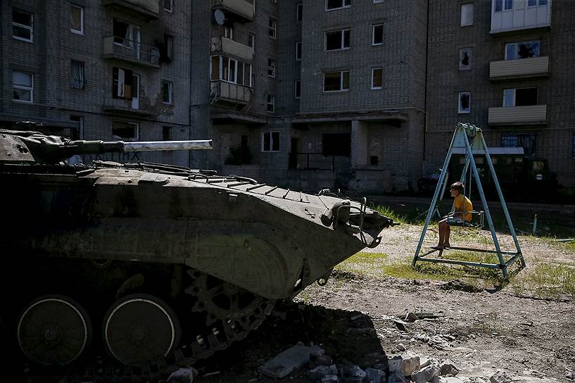 Авдеевка, Донецкая область, Украина. Украинский бронетранспортер возле дома, поврежденного во время боевых действий