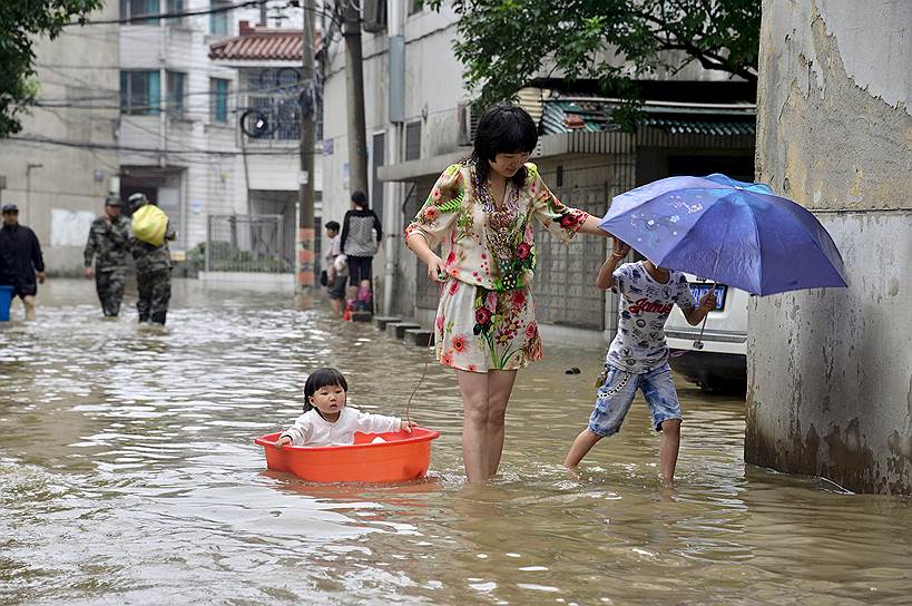 Чанчжоу, Китай. Местные жители во время наводнения, вызванного сильным ливнем
