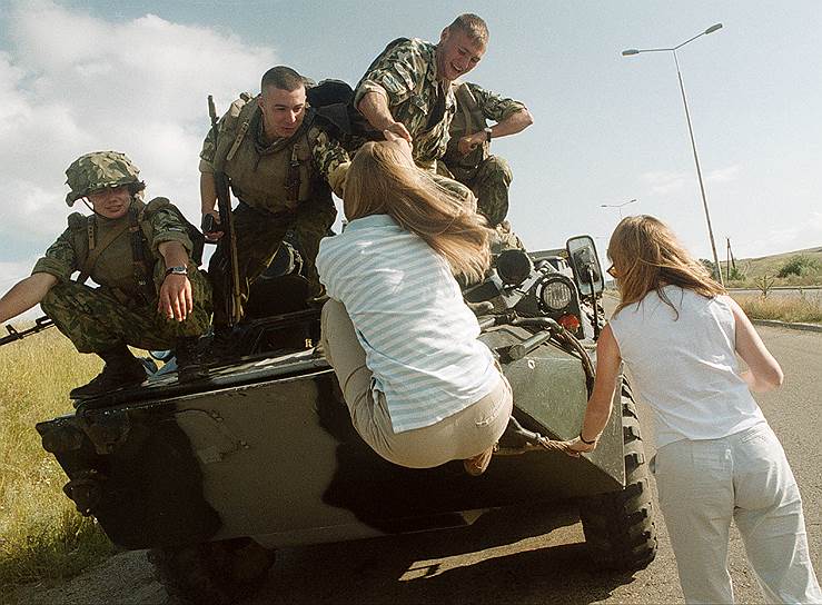 1999 год. Сербские девушки при помощи солдат российских миротворческих сил в Косово пытаются залезть на броню российского БТР