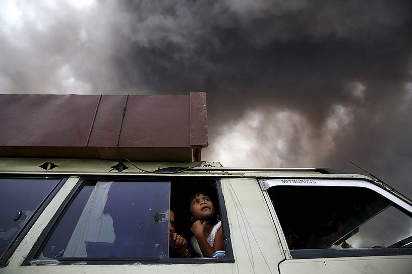 Северная Суматра, Индонезия. Семья, уезжающая из опасной зоны во время извержения вулкана Синабунг 