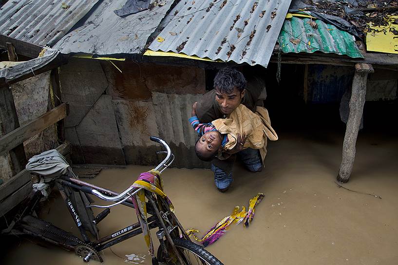 Шринагар, Индия. Мужчина эвакуирует ребенка из затопленного дома