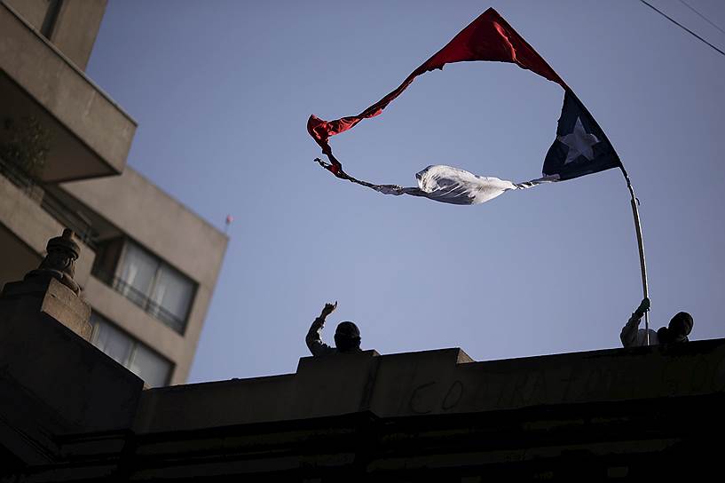 Сантьяго, Чили. Протестующие машут сожженным флагом страны во время демонстрации за изменения в системе государственного образования