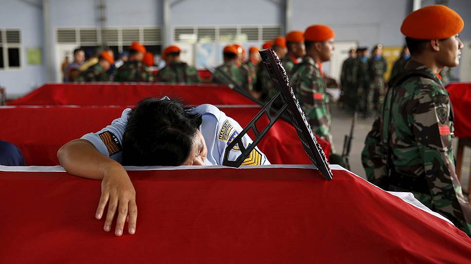 Медан, Индонезия. Индонезийская женщина-солдат, обнимает гроб мужа (также солдата), который погиб при крушении военного самолета С-130 Hercules