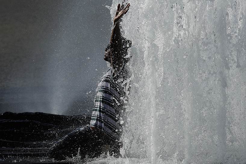 Берлин, Германия. Мужчина купается в фонтане во время сильной жары