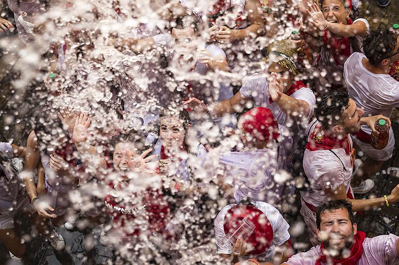 Памплона, Испания. Люди брызгают водой, празднуя официальное открытие Санферминес — недельной фиесты