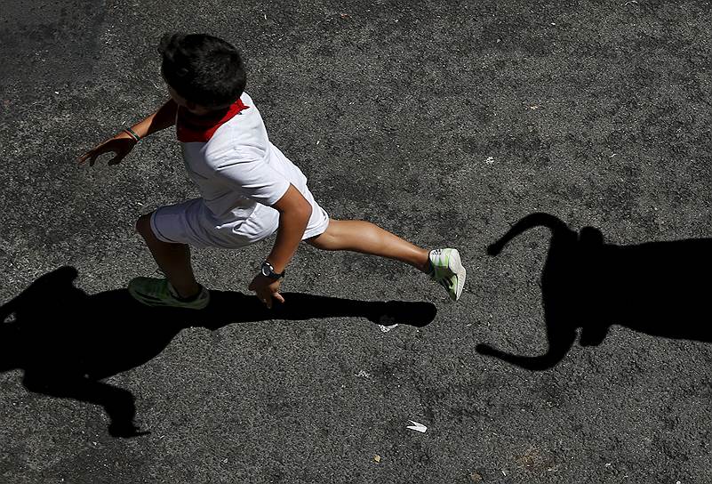 Памплона, Испания. Мальчик убегает от игрушечного быка