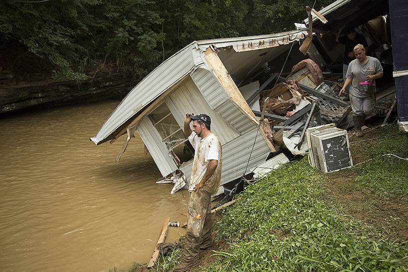Пэйнтсвил, США. Люди стоят на месте, где находился их дом, разрушенный в результате наводнения