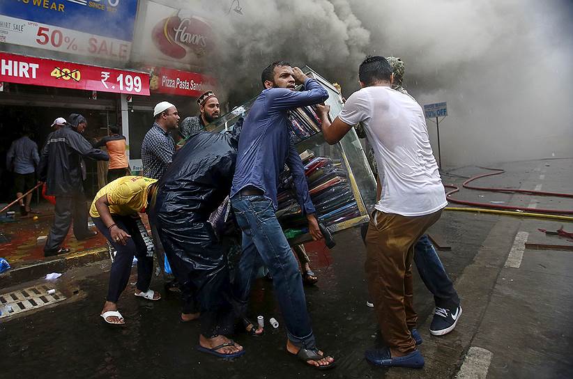 Мумбаи, Индия. Продавцы спасают имущество магазинов во время пожара в многоэтажном торговом комплексе