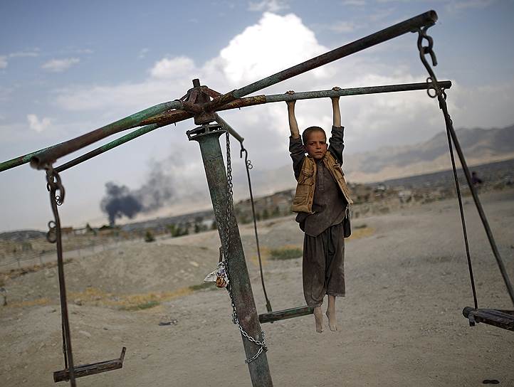 Кабул, Афганистан. Мальчик катается на карусели