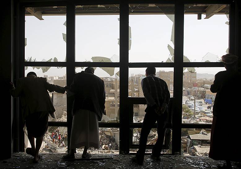 Сана, Йемен. Мужчины смотрят на последствия саудовского авиаудара по одному из городских рынков