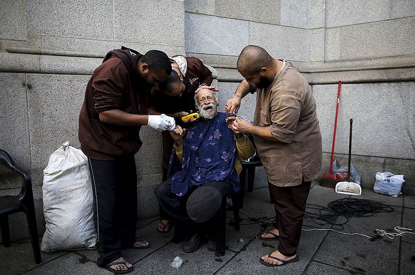 Сан-Паулу, Бразилия. Члены францисканского братства «O Caminho» стригут волосы и ногти бездомному возле церкви в центре города