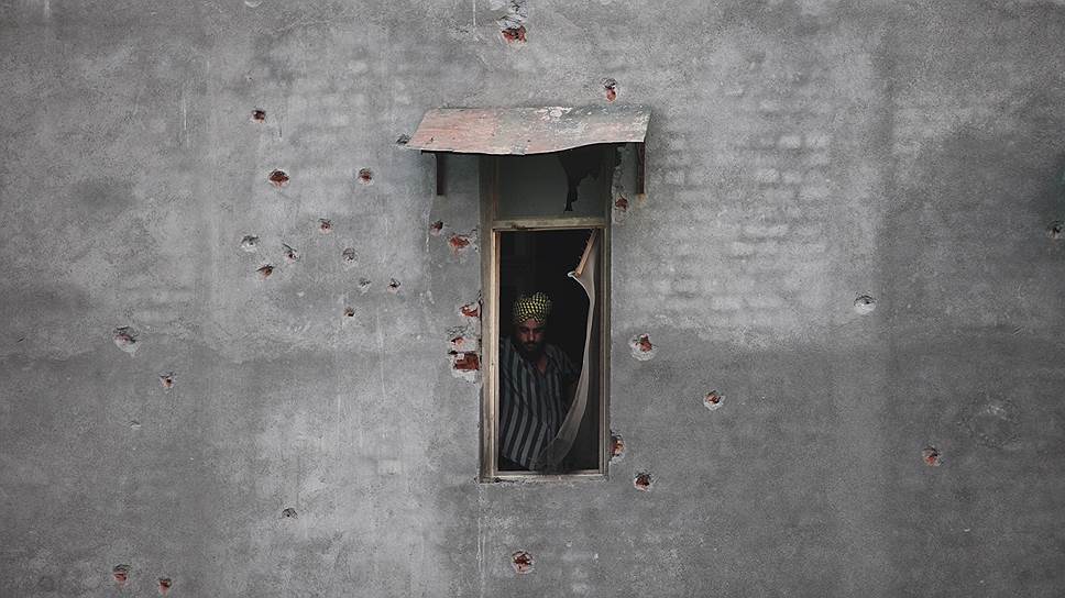 Дина Нагар, Индия. Мирный житель смотрит в окно после обстрела города боевиками