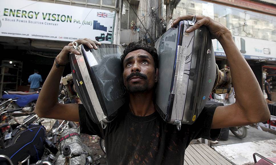 Карачи, Пакистан. Мужчина несет кинескопы для сборки самодельных телевизоров