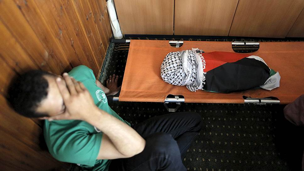 Кфар-Дума, Палестина. Скорбящий человек у тела полуторагодовалого ребенка, погибшего при поджоге дома израильскими экстремистами 