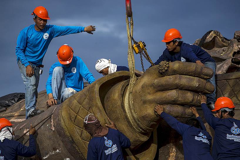 Хуахин, Таиланд. Рабочие с помощью крана поднимают статую короля Рамы I