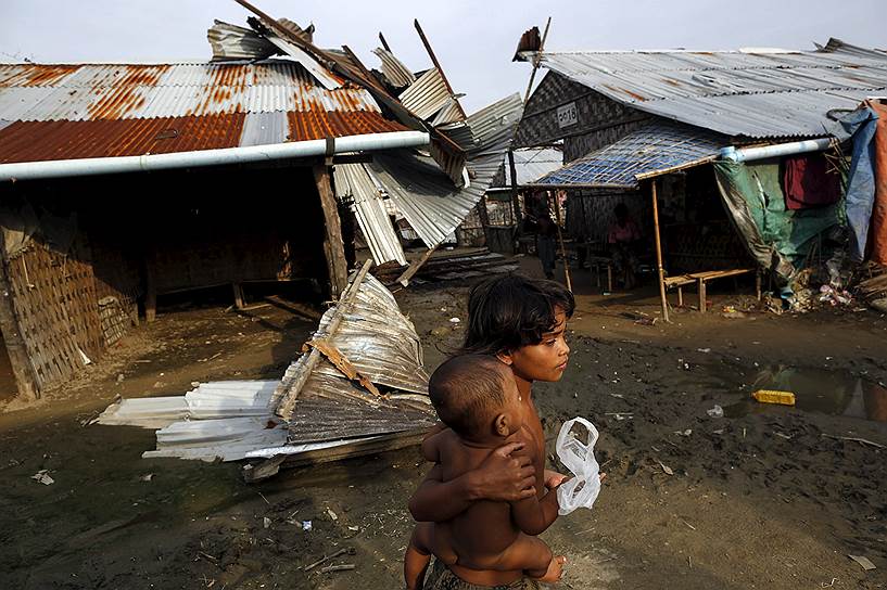 Ракхайн, Мьянма. Мусульманки-рохинья среди поврежденных домов в лагере для беженцев