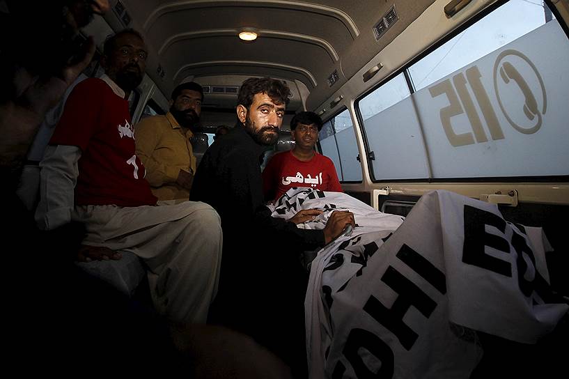 Карачи, Пакистан. Абдул Маджид, брат Шафката Хусейна, осужденного за убийство ребенка, сидит в машине скорой помощи рядом с телом брата после его казни