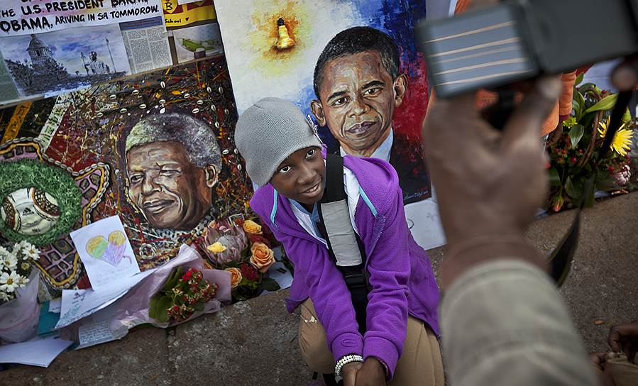 Претория, ЮАР. Родители фотографируют ребенка на фоне изображения президента США Барака Обамы и бывшего-президента ЮАР Нельсона Манделы 