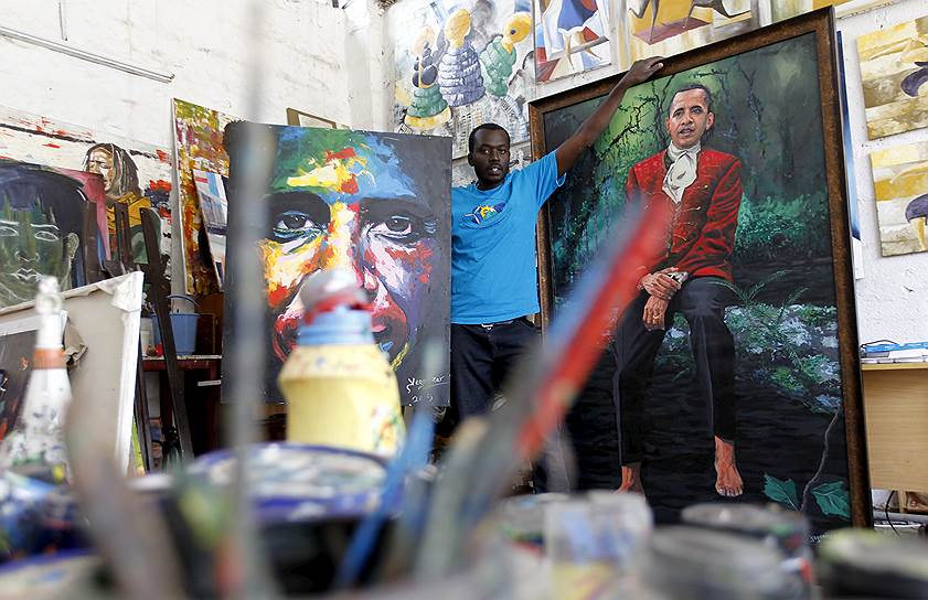 Кенийский художник Эванс Йегон позирует перед портретом президента США Барака Обамы в своей мастерской в столице Кении Найроби
