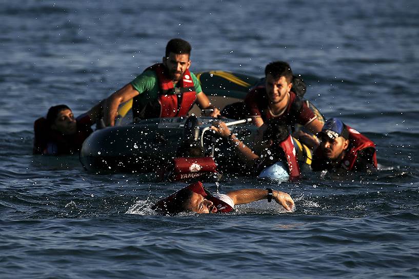 Остров Кос, Греция. Беженцы из Сирии, прибывшие к острову на резиновой лодке с отказавшим мотором, плывут к берегу