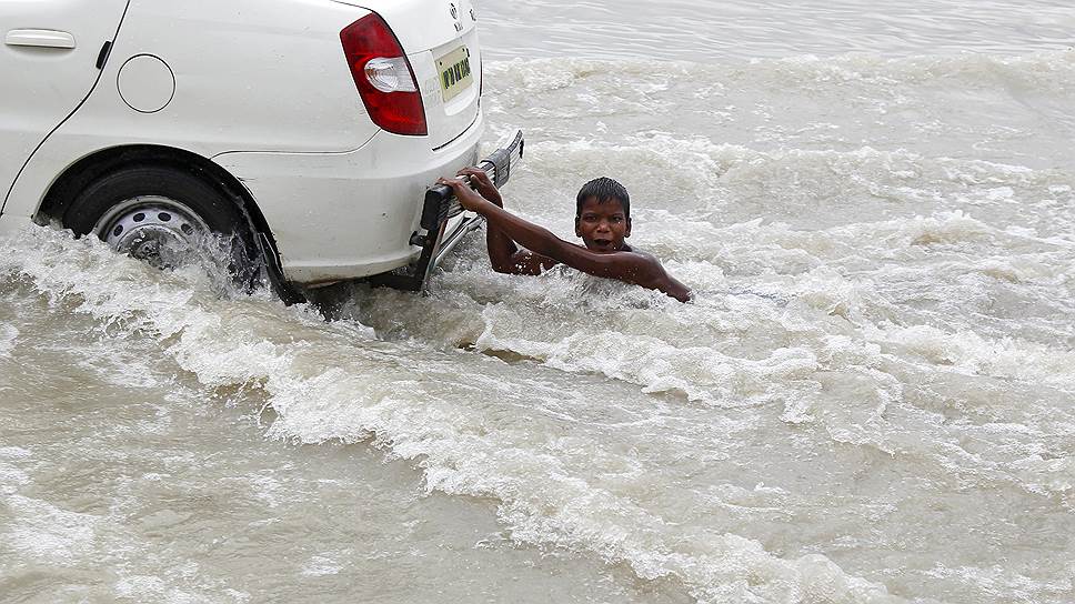 Аллахабад, Индия. Мальчик играет на улице во время наводнения, вызванного повышением уровня реки Ганг после проливных дождей