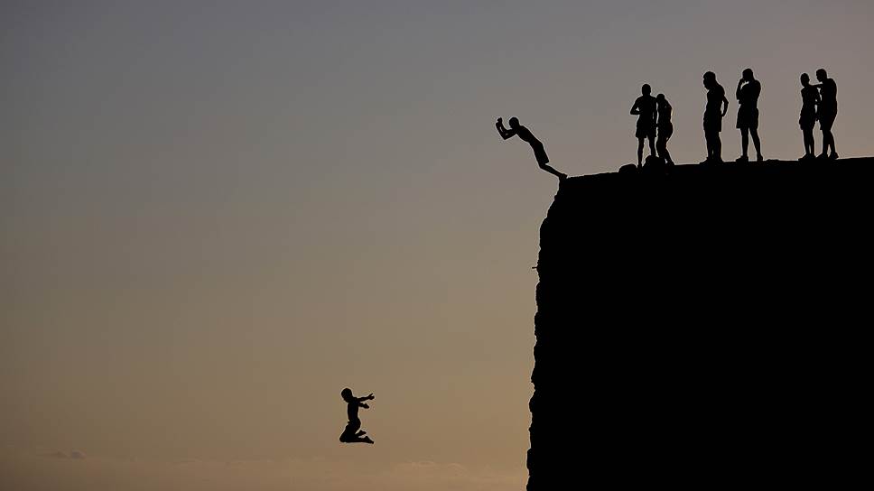 Акра, Израиль. Арабские дети прыгают со склона в Средиземное моер