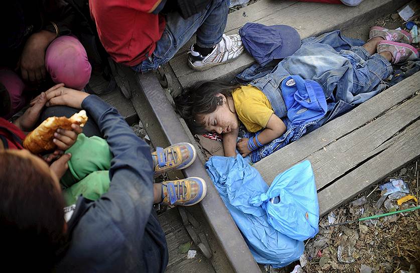 Четырехлетняя сирийская девочка спит недалеко от железнодорожного вокзала города Гевгелия (Македония), ожидая поезд, чтобы отправиться в Европу  