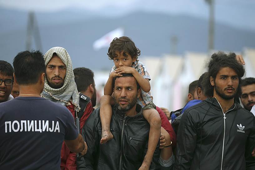 Мигранты во временном лагере для беженцев возле железнодорожного вокзала в городе Гевгелия (Македония) ожидают поезд, идущий в Сербию
