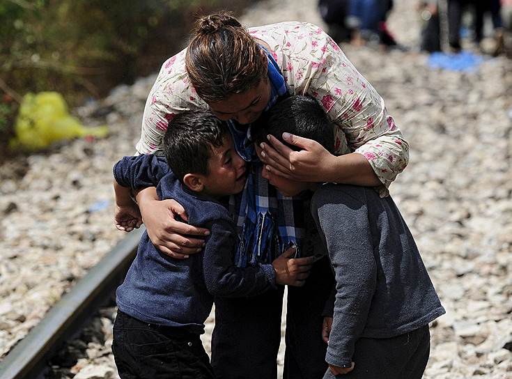 Мать обнимает своих сыновей после пересечения границы