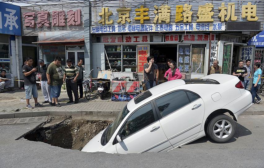 Пекин, Китай. Автомобиль, попавший в провал грунта на одной из улиц города