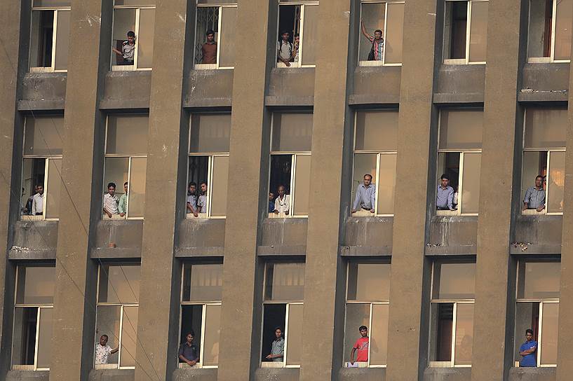 Дакка, Бангладеш. Местные жители смотрят из окон здания отборочный матч Чемпионата мира по футболу между сборными Иордании и Бангладеш