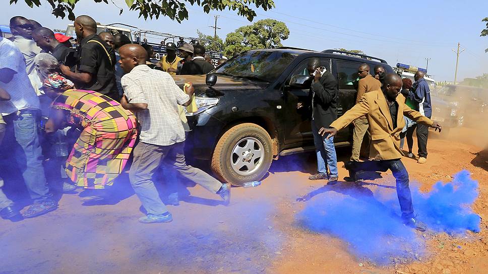 Джинджа, Уганда. Сторонник бывшего премьер-министра страны Амамы Абази пинает гранату со слезоточивым газом, выпущенную полицией для разгона акции протеста