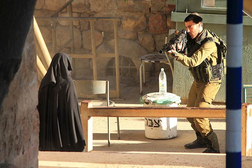 Хеврон, Палестина. Израильский солдат целится в 19-летнюю Хадиль аль-Хашламун. 22 сентября Хадиль была застрелена на блокпосте в Хевроне — по версии Израиля за то, что пыталась зарезать солдата. Официальная Палестина потребовала международного расследования инцидента