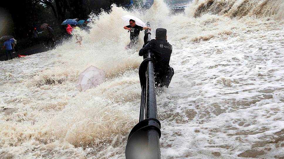 Ханчжоу, Китай. Местные жители и туристы спасаются от вышедшей из берегов реки Цяньтан после прохождения тайфуна Дуджуан 