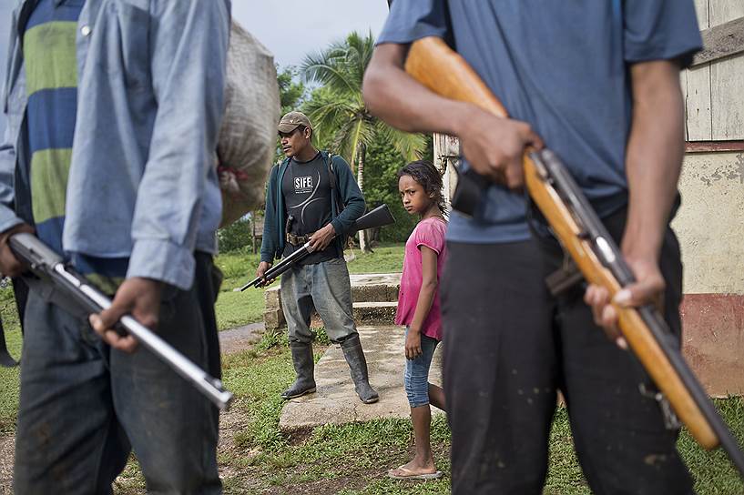 Индейцы из племени мискито с оружием, которое, по их словам, они используют для защиты родных земель. «Из-за нехватки продовольствия и медикаментов наши люди вынуждены искать убежища в Гондурасе. В этом году у нас богатый урожай риса, но мы не можем собрать его, так как колонисты попросту убьют нас»,— рассказывает один из членов племени