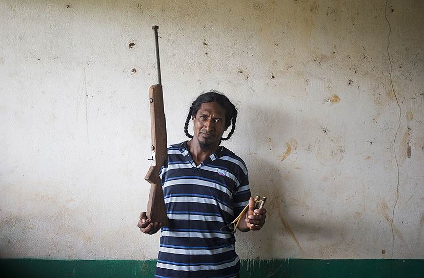Индеец-мискито, пожелавший не разглашать своего имени, позирует с винтовкой и рогаткой