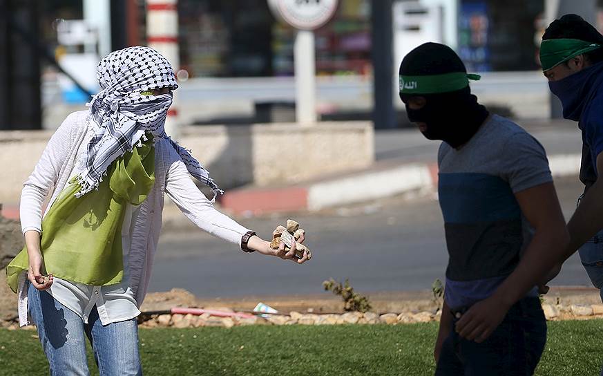 Рамалла, Палестина. Девушка подает камни участникам столкновений с израильскими военными