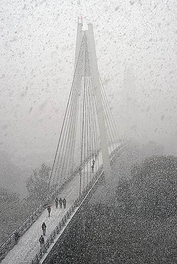 Москва, Россия. Павшинский пешеходный мост во время первого снегопада в столице