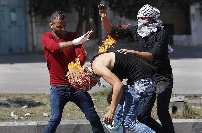 Хеврон, Палестина. Протестующие тушат своего товарища, загоревшегося от «коктейля Молотова»