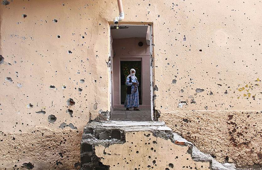 Диярбакыр, Турция. Женщина на пороге дома, изрешеченного пулями