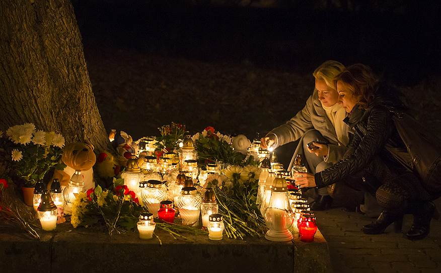 Люди зажигают свечи и несут цветы к посольству России в Литве в память о погибших в авиакатастрофе в Египте