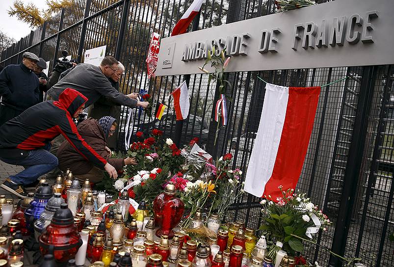 Жители Варшавы возлагают цветы к мемориалу в память погибшим
