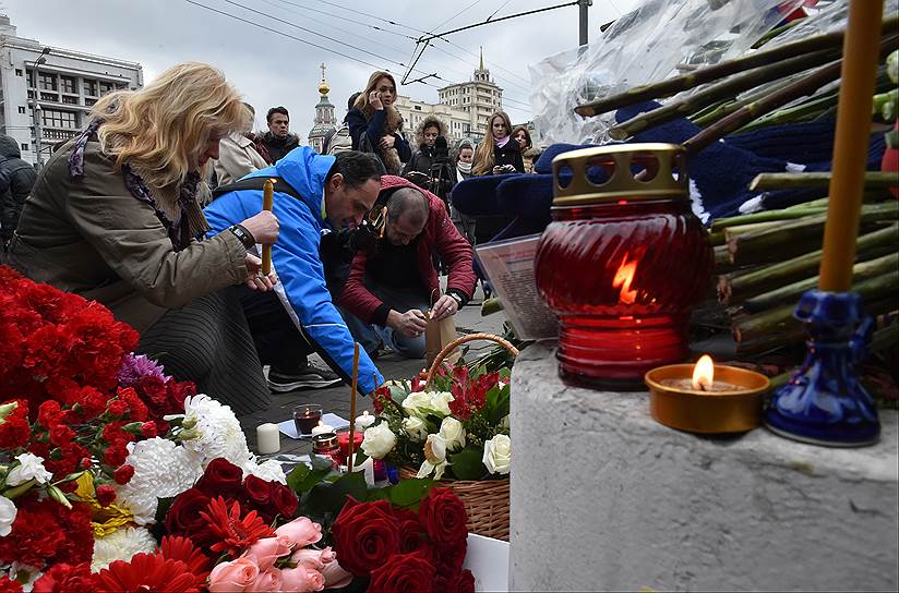 Люди приносят цветы и свечи к французскому посольству в Москве